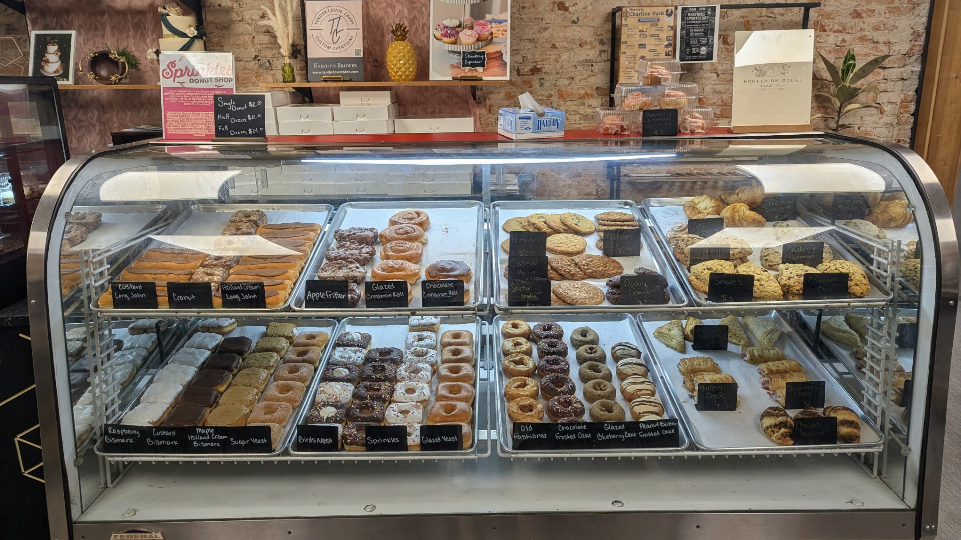 Bakery case filled with fresh donuts, cinnamon rolls, scones and cookies